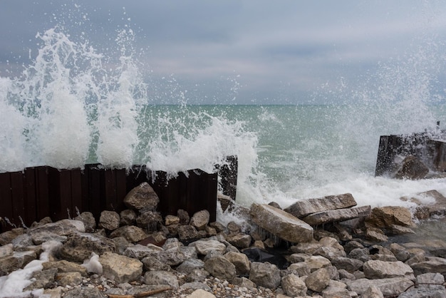 Foto las olas salpicando las rocas en la costa contra el cielo