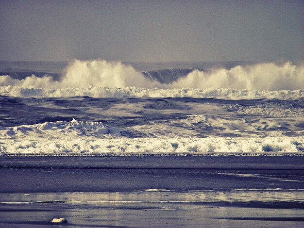 Las olas salpicando las rocas en la playa