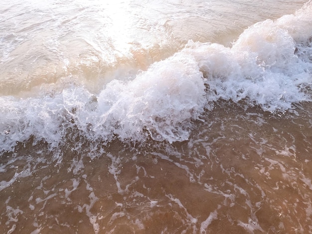 Olas suaves del océano en una playa de arena limpia de cerca