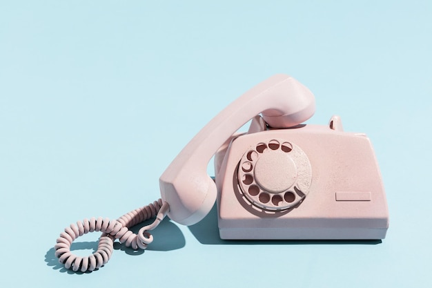 Oldschool rosa Telefon auf blauem Hintergrund Telekommunikation Vintage-Objekte