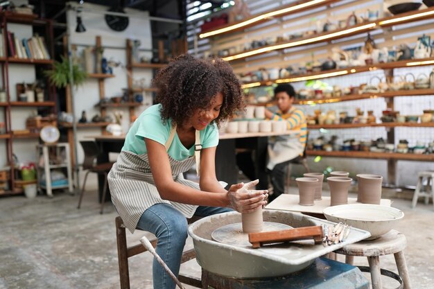 Oleiro de mão jovem fazendo vaso de barro na oficina de cerâmica Proprietário da empresa
