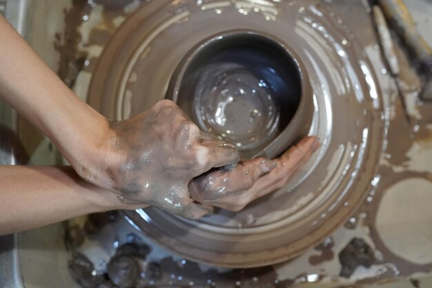 Oleiro de mão jovem fazendo vaso de barro na oficina de cerâmica Proprietário da empresa