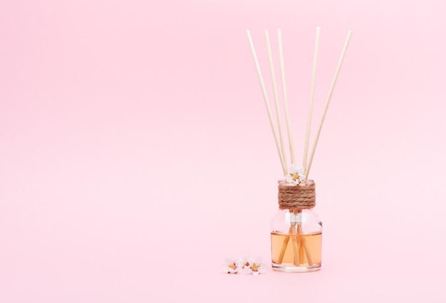 Foto Óleo aromático difusor com reed sticks em um fundo rosa