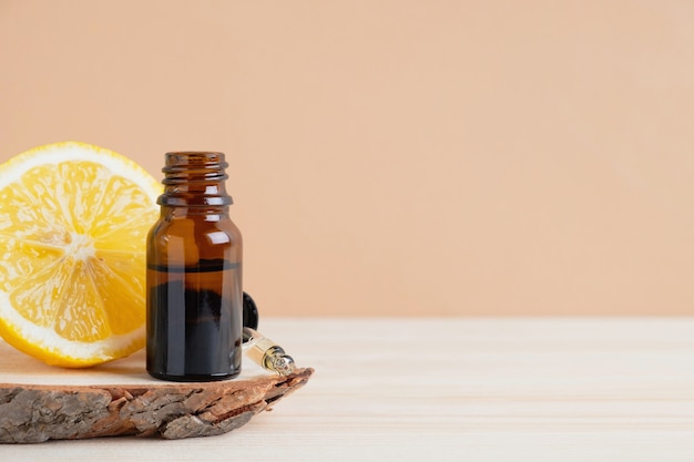 Óleo essencial de cítrico e fruta limão em um suporte de madeira e fundo laranja claro