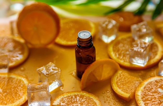 Óleo essencial de laranja em um fundo amarelo Foco seletivo