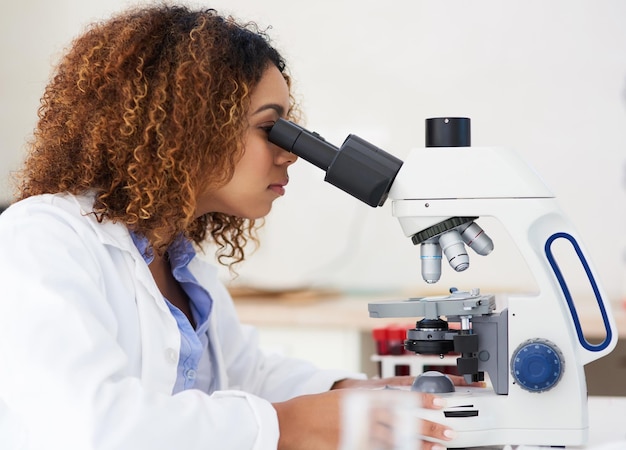 Foto olhando mais de perto uma foto recortada de uma jovem cientista olhando para um microscópio