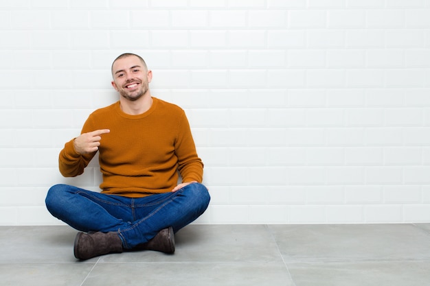 olhando orgulhoso, confiante e feliz, sorrindo e apontando para si mesmo ou fazendo o sinal número um