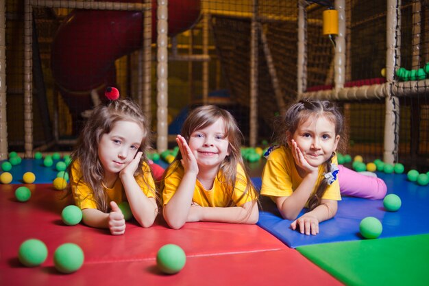 Olhando para a câmera Menina feliz brincando e se divertindo no play center