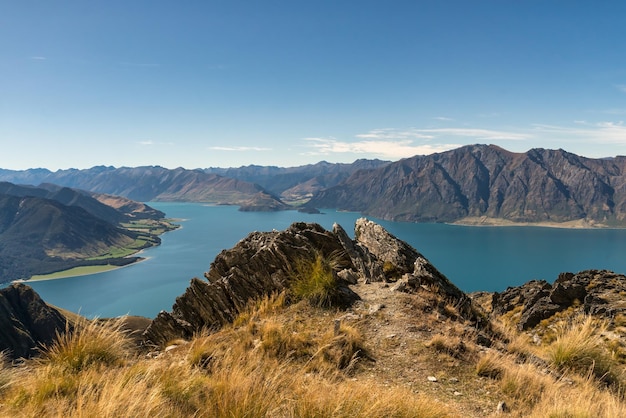 Olhando para baixo sobre o Lago Hawea de perto do cume da trilha de caminhada do pico do istmo perto do pescoço