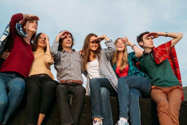 Olhando para o futuro. grandes planos, sonhos e ideias. grupo de diversos jovens sentados juntos