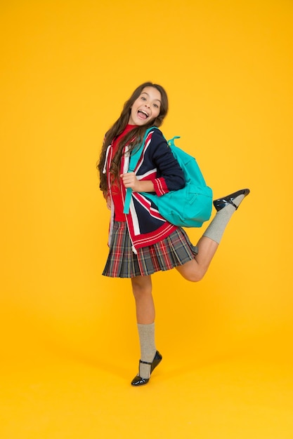 Olhar de beleza. escola britânica na Inglaterra. férias na Grã-Bretanha. conceito de viagem. uniforme de menina segura mochila. criança feliz com bandeira inglesa na jaqueta. ir estudar para a Inglaterra. aprendendo idiomas.