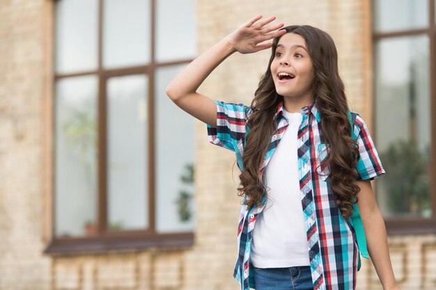 Olhar surpreso Menina olha para longe ao ar livre Look fashion de criança pequena Estilo casual na moda Tendência elegante Salão de cabeleireiro Férias de verão Que espaço de cópia surpresa