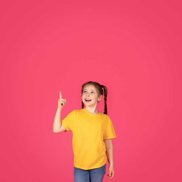 Foto olhe lá criança do sexo feminino animada apontando para cima com o dedo mostrando o espaço da cópia