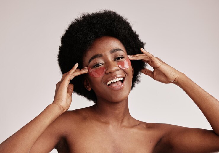 Foto olhos de cuidados com a pele e máscara facial em mulher negra em estúdio feliz com produto cosmético dermatológico modelo estético com mãos para adesivo de colágeno para saúde, bem-estar e pele facial brilha fundo cinza