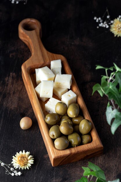 Oliven mit hausgemachtem Käse auf Holzbrett