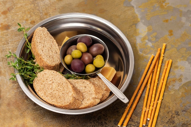 Oliven und Baguettestücke in einer Metallschüssel