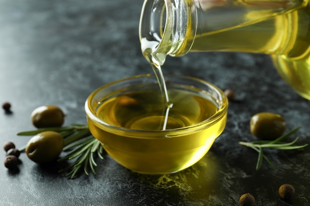 Foto olivenöl aus der flasche in die schüssel gießen, schließen