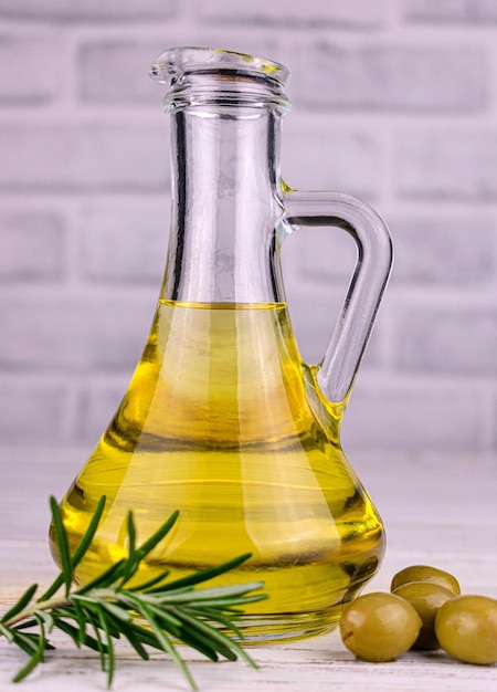 Olivenöl in Glaskies auf weißem Hintergrund