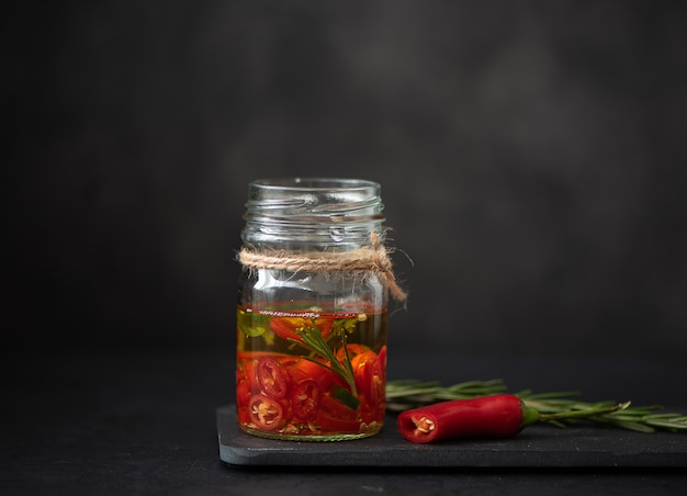 Olivenöl mit Chili und Kräutern im Glas