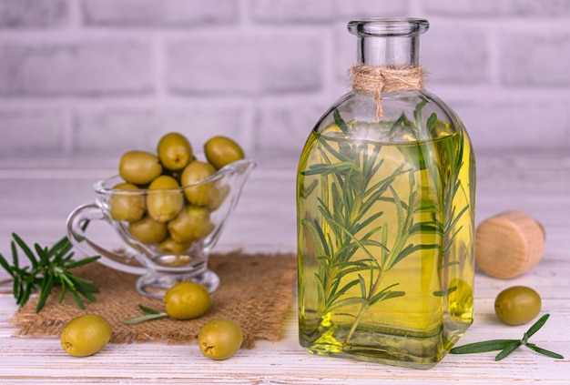 Olivenöl mit frischen Rosmarinzweigen in einer Glasflasche