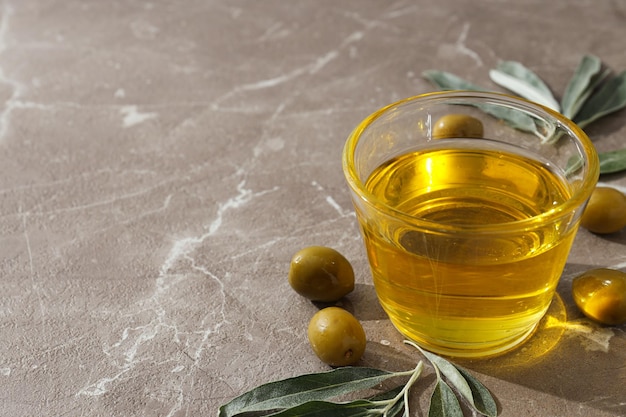Olivenöl und Oliven auf grauem Hintergrund Platz für Text