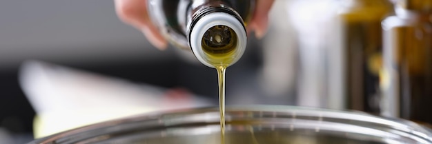 Olivenöl wird aus einer Flasche in einen Topf gegossen