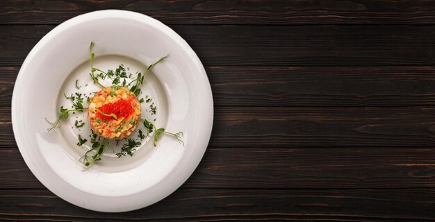 Olivier-Salat mit rotem Kaviar auf einem hölzernen Hintergrund Banner