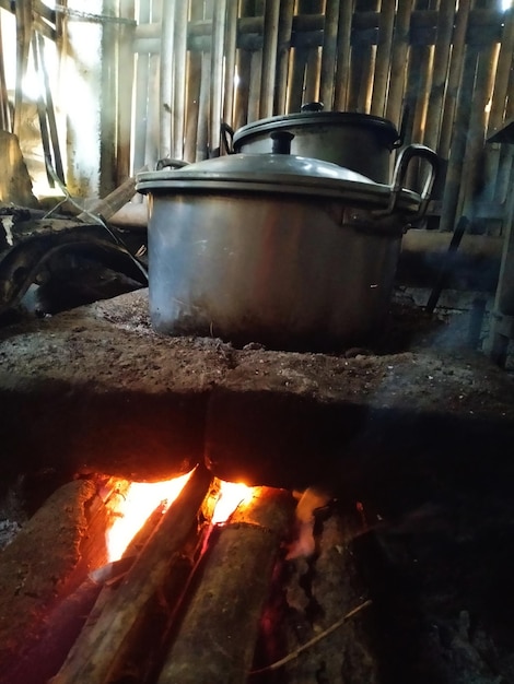 Una olla al fuego está en una estufa con una llama en el fondo