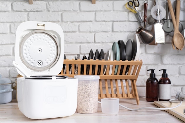 Olla arrocera eléctrica sobre encimera de madera en la cocina