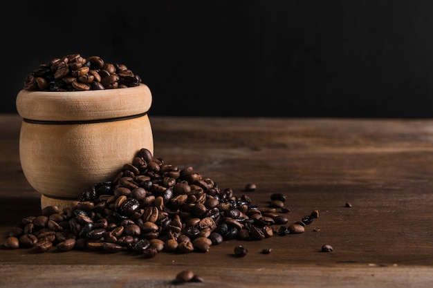 Foto olla de barro con granos de café
