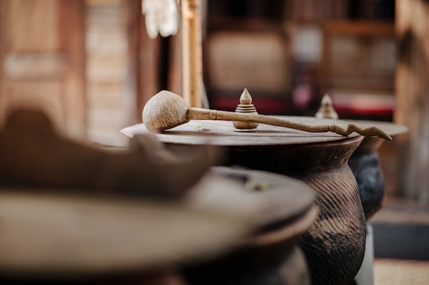 Foto olla de barro con tapa de madera cubierta con cucharón de agua