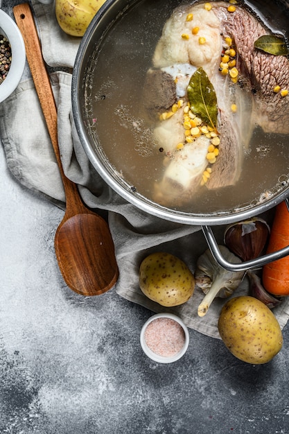 Olla con carne de caldo de huesos. Verduras cocinar ingredientes y especias en la mesa de la cocina. Vista superior