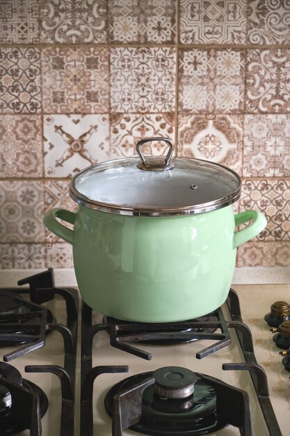 Foto olla de cocción en la estufa de gas en la cocina de casa y agua hirviendo en la olla