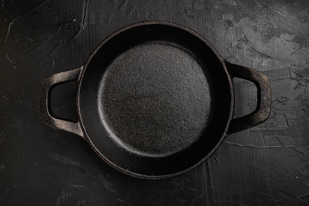 Olla de cocina negra con espacio de copia para texto o comida con espacio de copia para texto o comida vista superior plana sobre fondo de mesa de piedra oscura negra