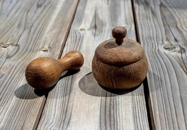 Olla de madera cerrada con tapa de madera y mortero sobre mesa