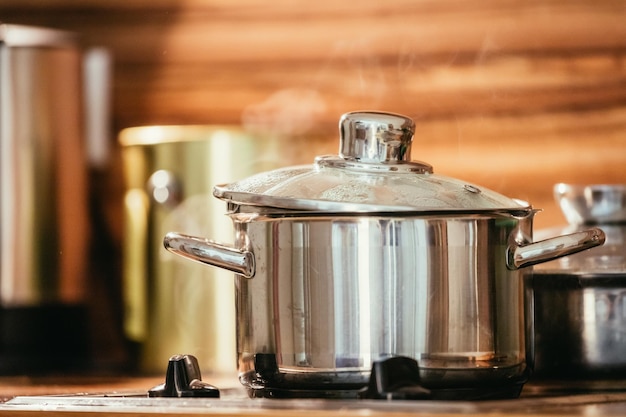 Olla de metal humeante en la madera de la cocina