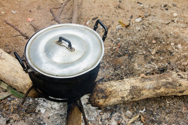 Una olla negra de acero inoxidable se coloca en la estufa durante mucho tiempo y ahora se usa para hacer coo.