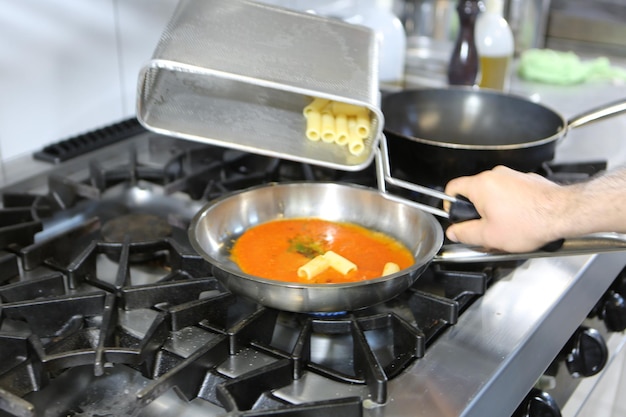 olla con pasta en la estufa de fuego cocinando