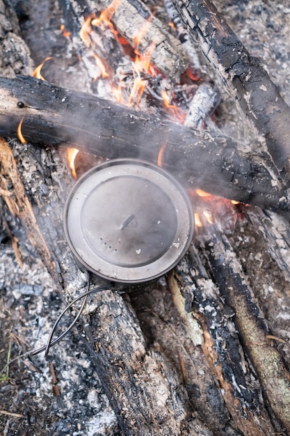 Olla de preparación de puestos de comida en el campamento de fogatas de carbón día de verano