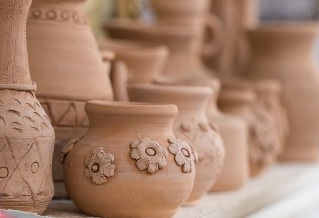 Ollas de barro en el estante, fondo borroso. manualidades para niños