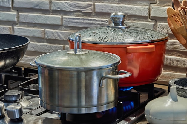 Ollas con comida para cocinar en la cocina con estufa de gas