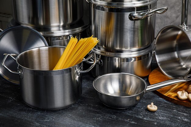 ollas y sartenes en la cocina sobre un fondo gris