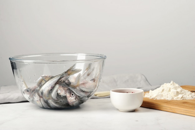 El olor crudo fresco en un plato de vidrio profundo está listo para freír en una harina con especias