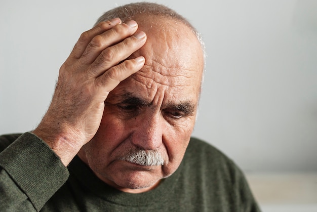 Olvidado hombre senior con una mano en la cabeza