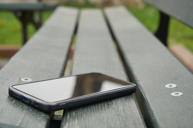 Olvídese del teléfono inteligente en un banco del parque perdido el teléfono inteligente