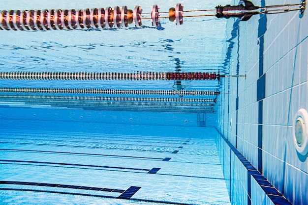 Olympisches Schwimmbad unter Wasserhintergrund.