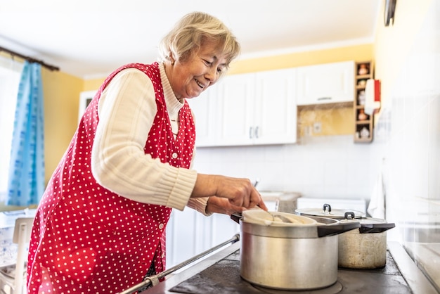 Foto oma kocht bryndzove halusky, ein traditionelles slowakisches gericht, in ihrem alten ofen.