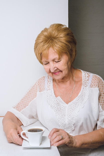 Foto oma trinkt kaffee in der küche