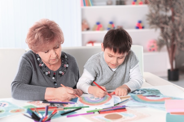 Oma und Enkel malen einen Regenbogen im Kinderzimmer