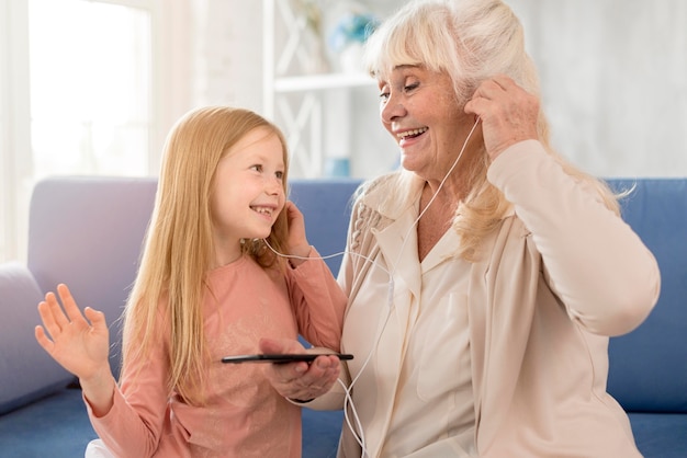 Oma und Mädchen hören Musik zu Hause